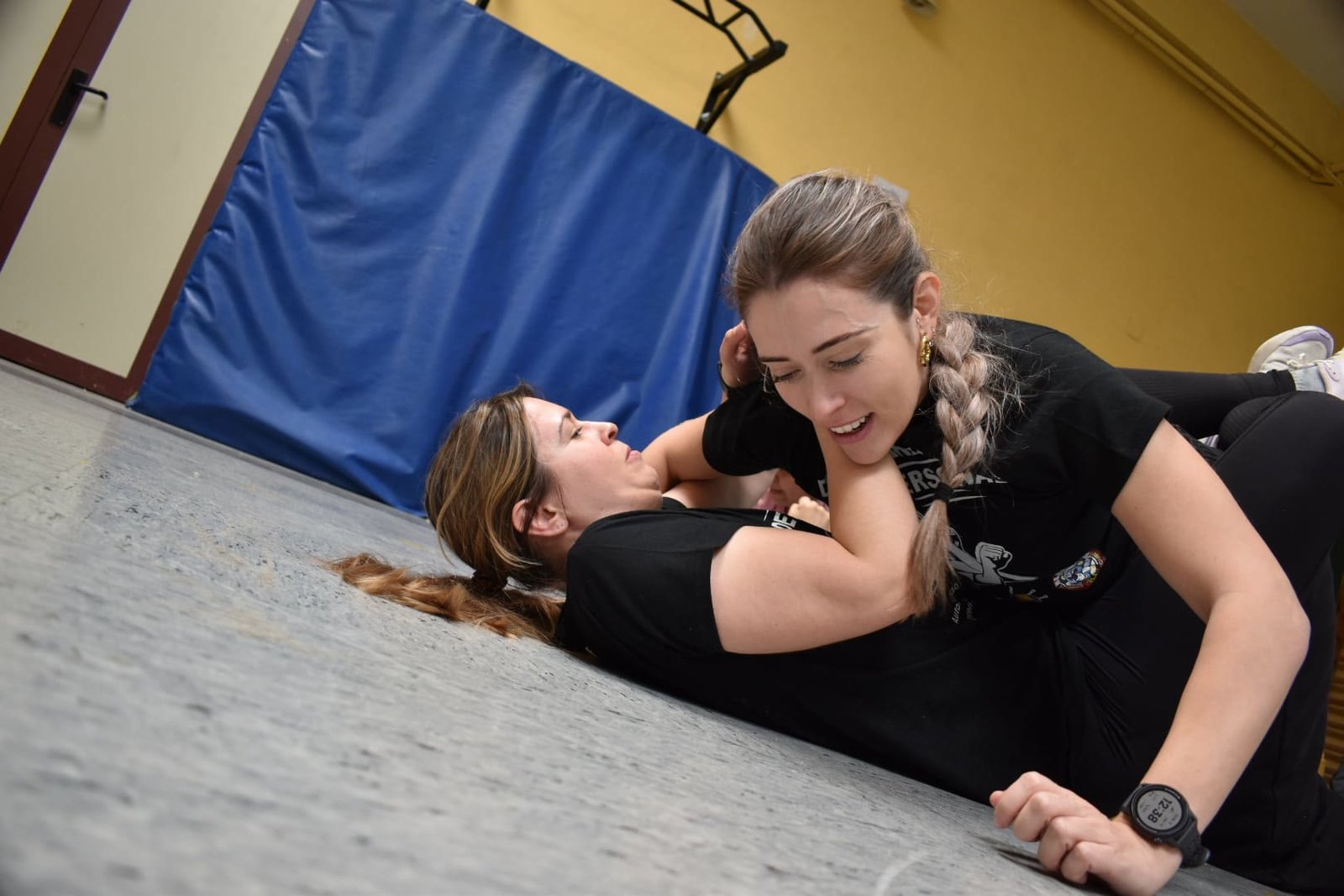 Dos alumnas practicando técnica de defensa personal en el suelo en Wu Xing Madrid, Hortaleza